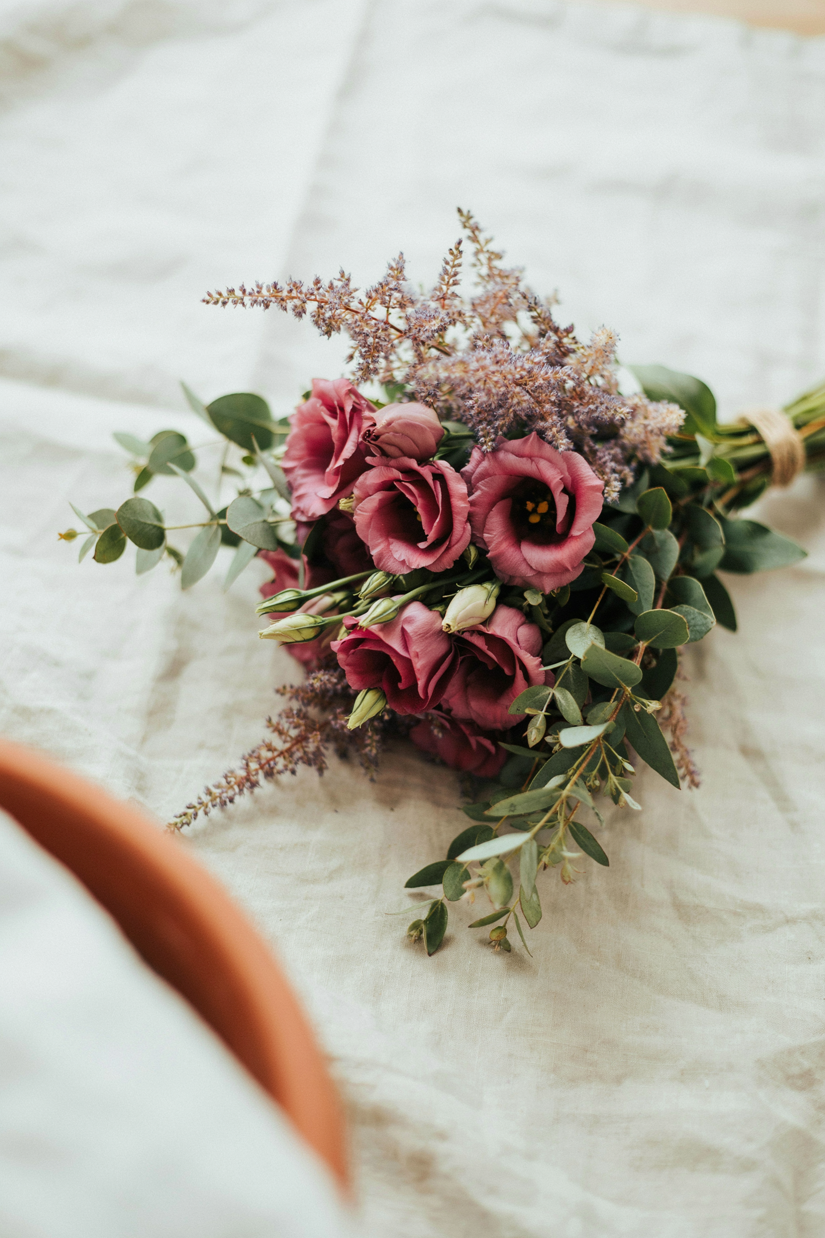 Delicate, airy bouquet of burgundy lisianthus layered with feathery plum astilbe and soft greenery