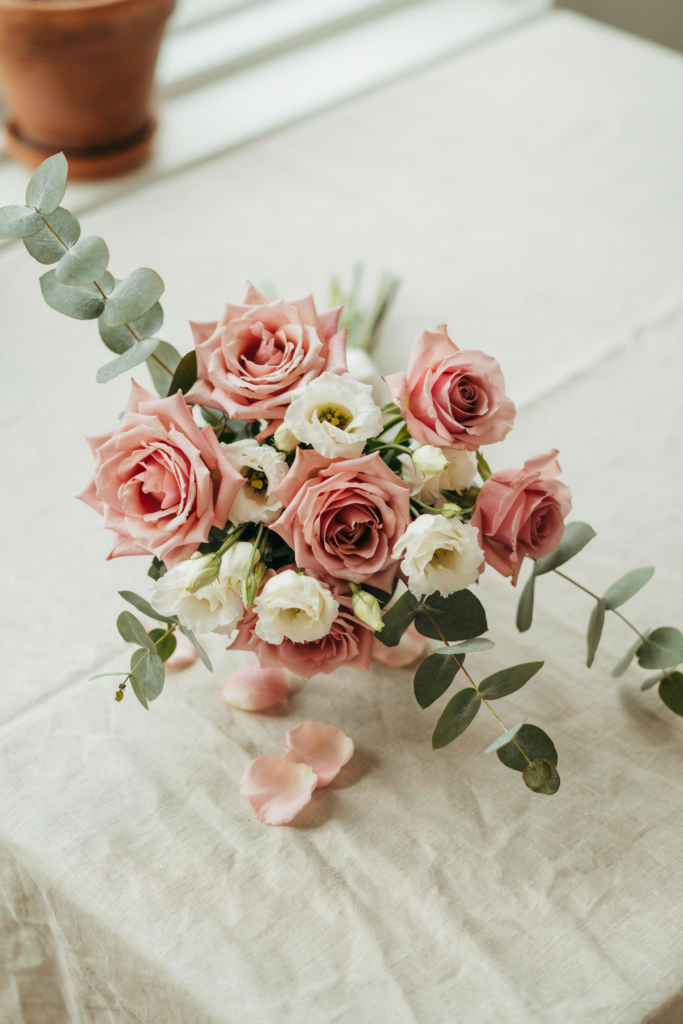 Delicate, garden-style bouquet of blush roses with small ivory lisianthus blooms and soft eucalyptus foliage