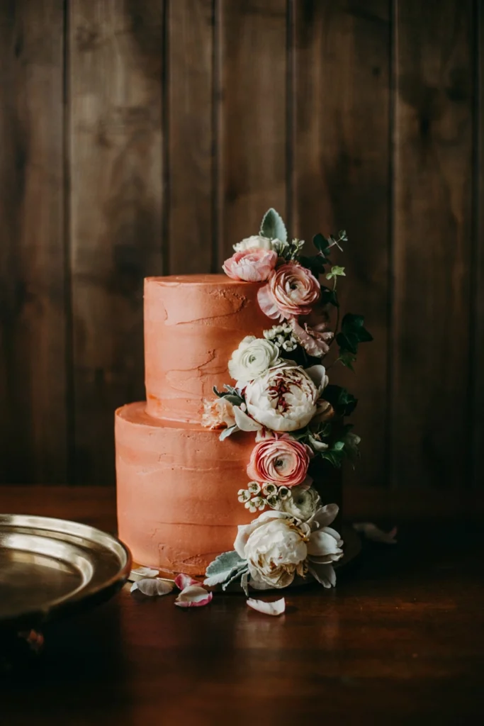 Burnt orange buttercream wedding cake with cascading silk florals