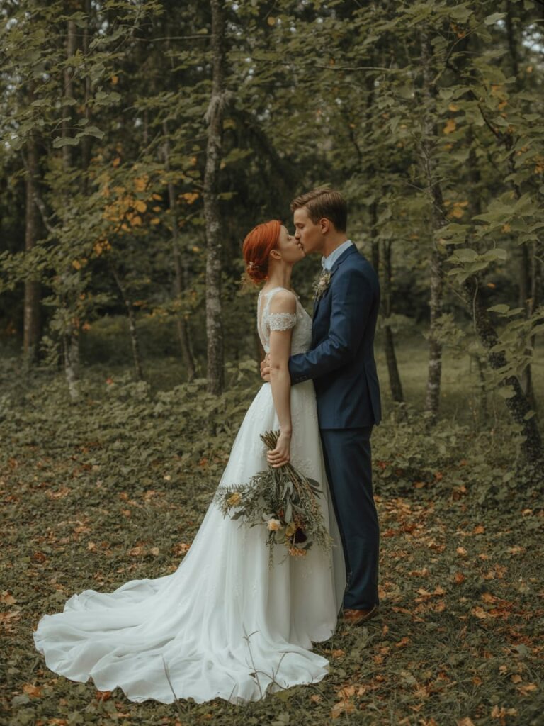 Romantic forest wedding scene showcasing seasonal foliage, layered textures, natural colors, atmospheric lighting, immersive outdoor setting, elegant and timeless wedding editorial photography