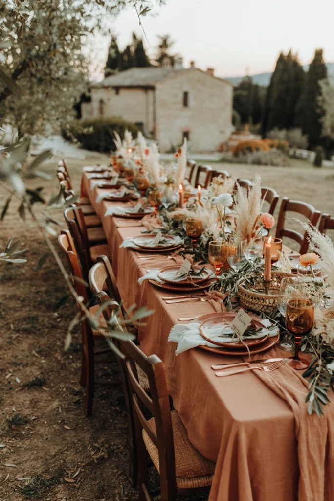 Earthy terracotta and olive wedding reception with woven textures on a long outdoor table
