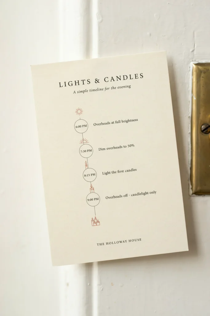 A small printed card with a simple timeline for when to dim overhead lights and switch on candles, propped near a light switch or breaker panel at the venue.