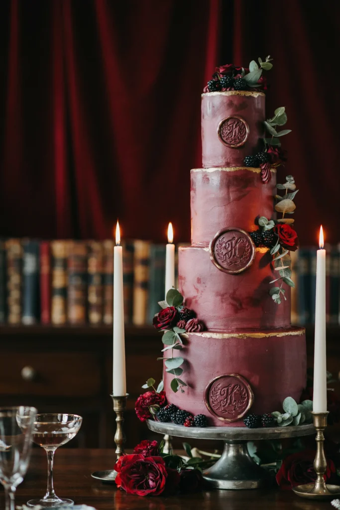 Dark burgundy and gold Bridgerton-inspired wedding cake with wax seal details