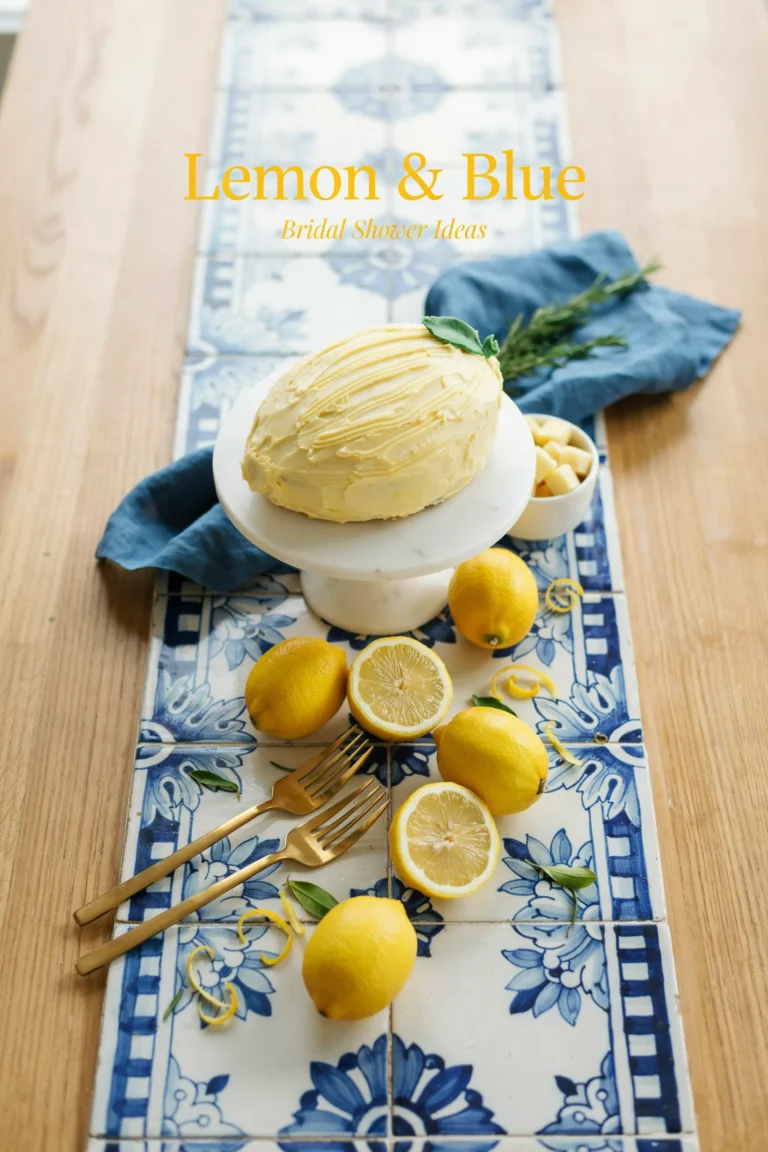 Overhead shot of a blue-and-white tiled table runner topped with fresh lemons, blue linen napkins, and a lemon-shaped cake, with soft natural light and a "Lemon & Blue Bridal Shower Ideas" text overlay in a citrus-yellow serif font.