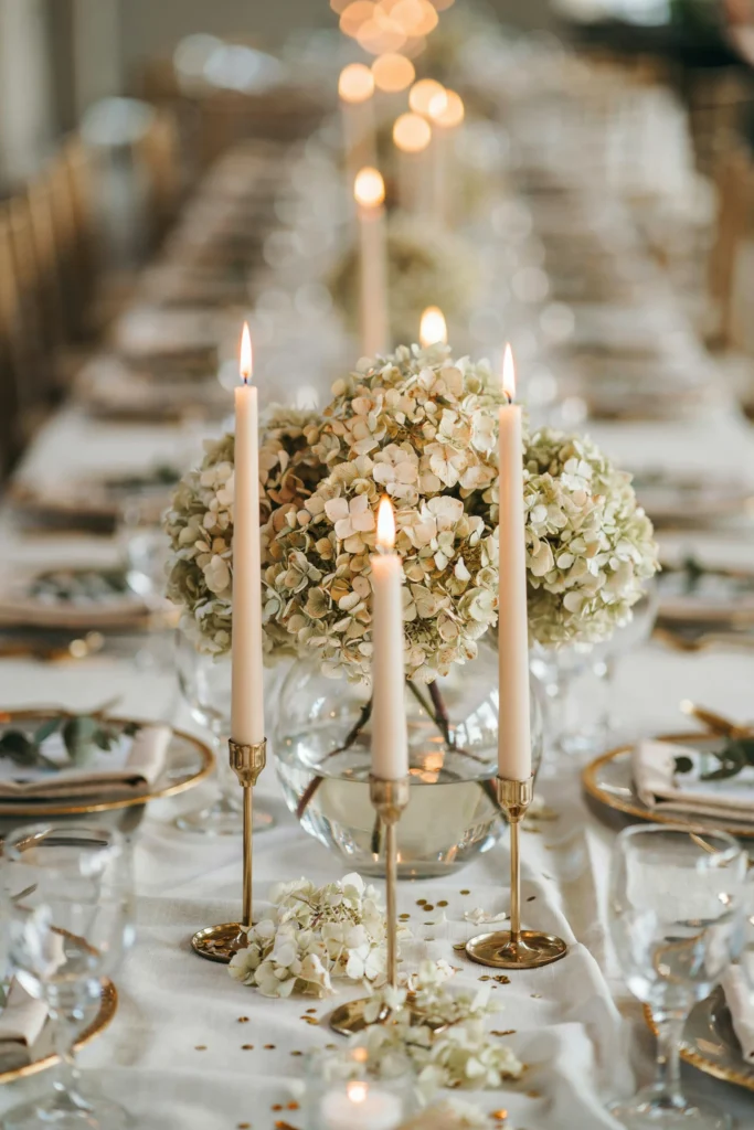Ivory hydrangea centerpiece in a glass vase on a wedding table