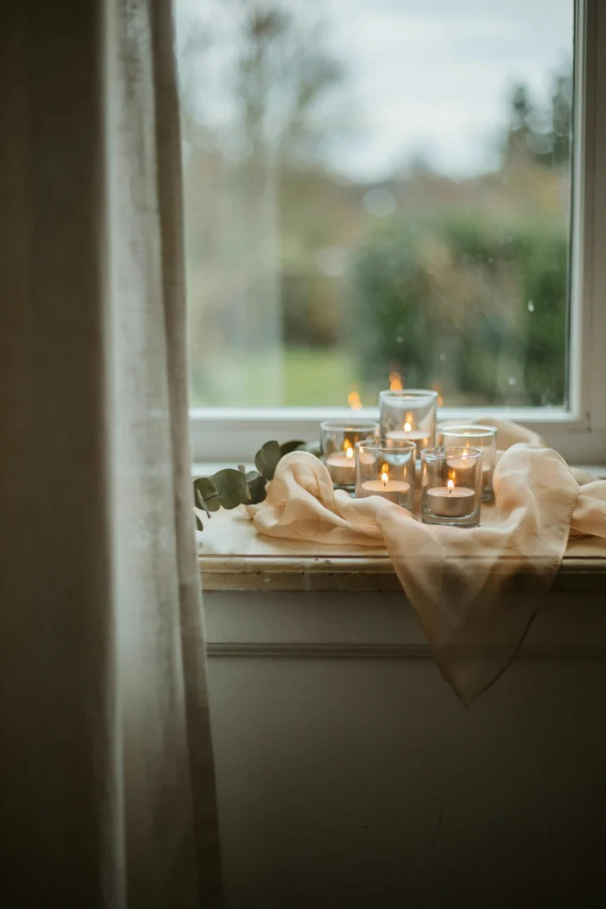 Flameless votive candles wrapped in sheer champagne tulle glowing softly on a table edge