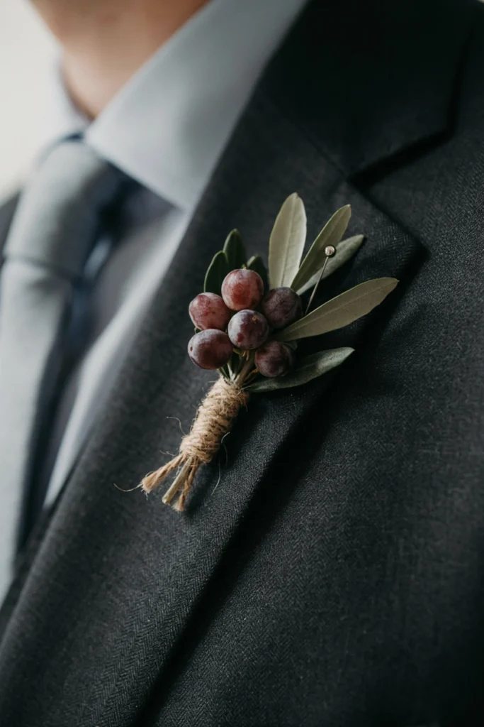 Olive sprig and plum berry boutonniere with twine wrap