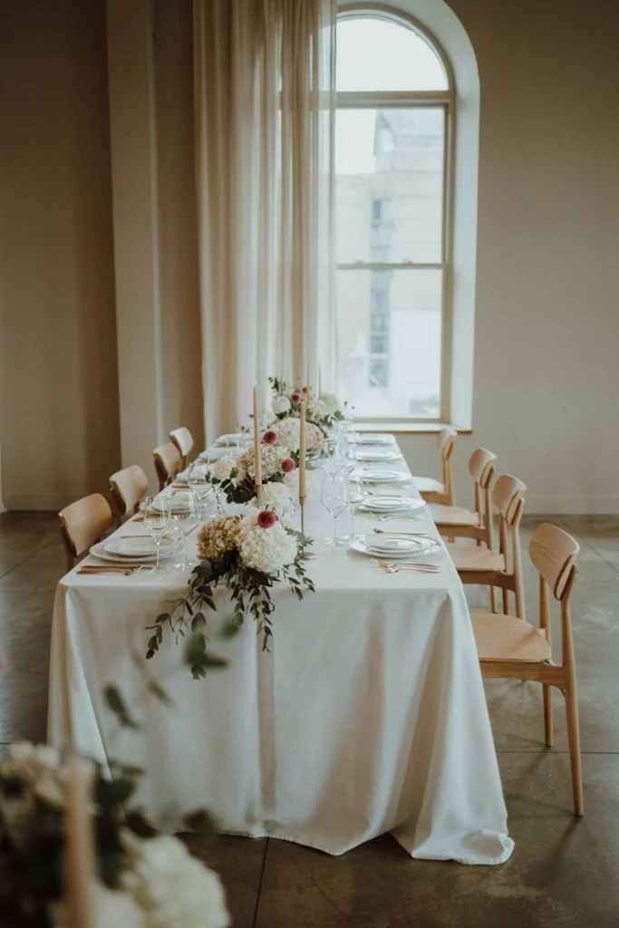 Whimsical spring table with raspberry, lavender, and sage florals in mismatched vintage vessels