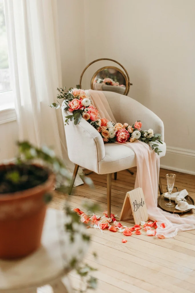 An accent chair for the bride-to-be decorated with a flowing sash, a small floral garland along the back, and a "Bride" sign, set slightly apart from the rest of the seating