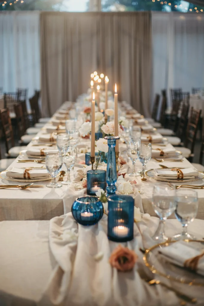 Blue glass votive candle holders clustered at varying heights on a bridal shower table