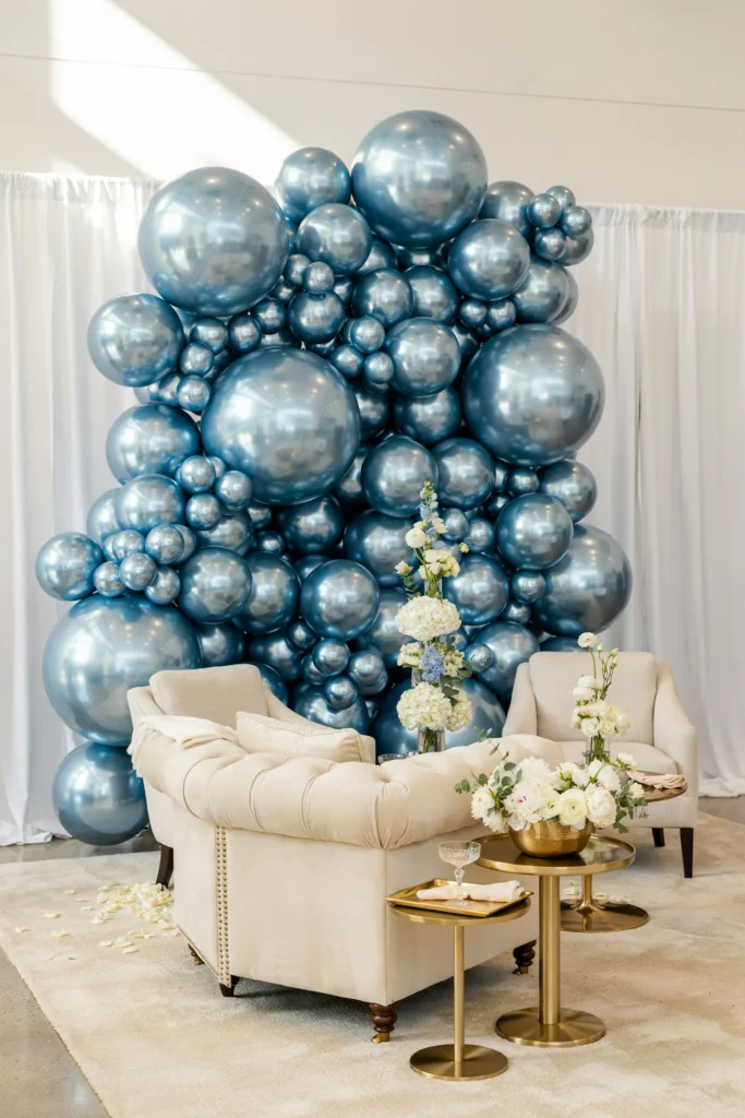 Wall of glossy metallic chrome blue balloons behind bridal shower seating