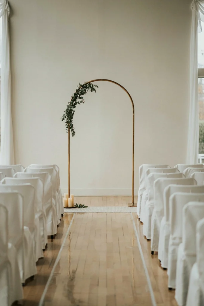 Simple gold metal arch frame as a minimalist small wedding photobooth backdrop