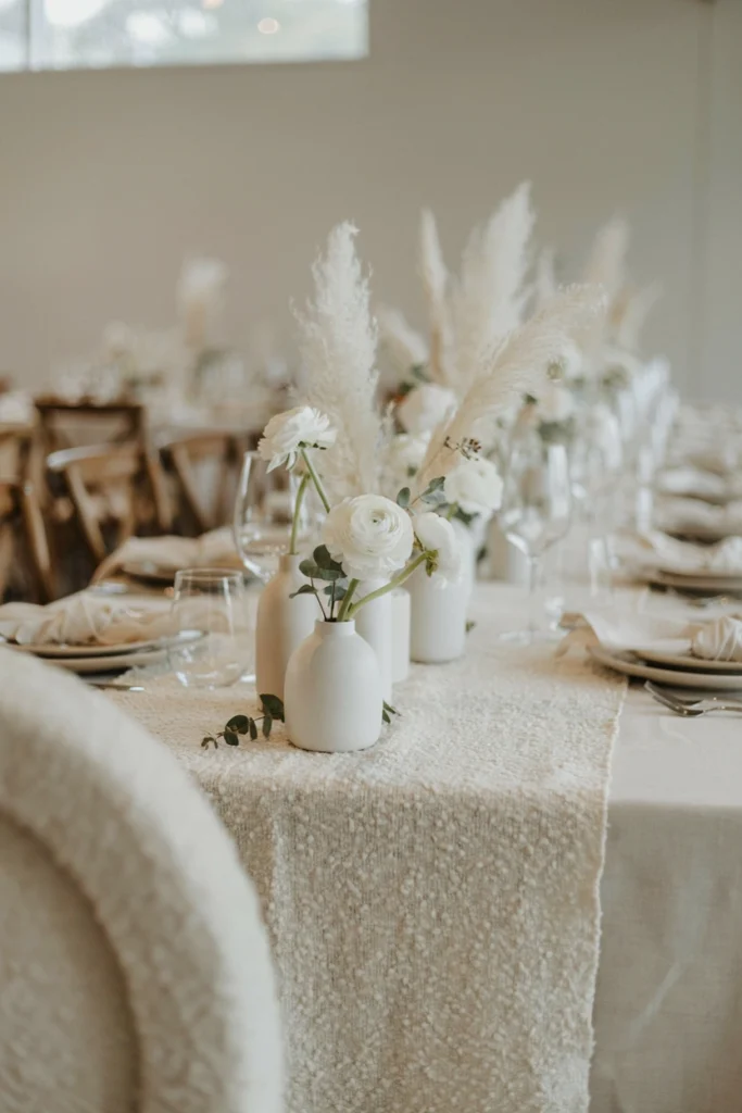 White-on-white winter wedding table with bouclé runner and pampas grass