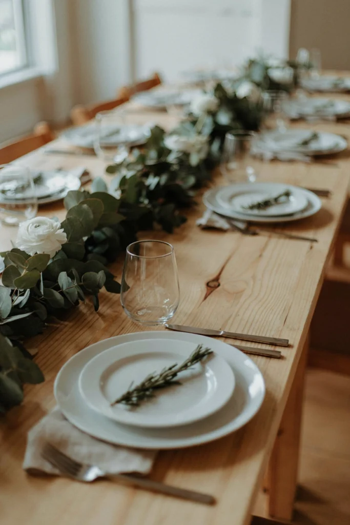 Minimalist bare wood wedding table with a single rosemary sprig