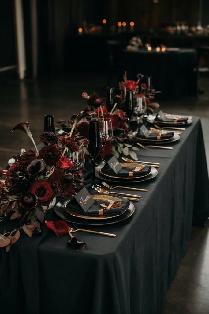 All-black winter wedding table with gold flatware and dark florals