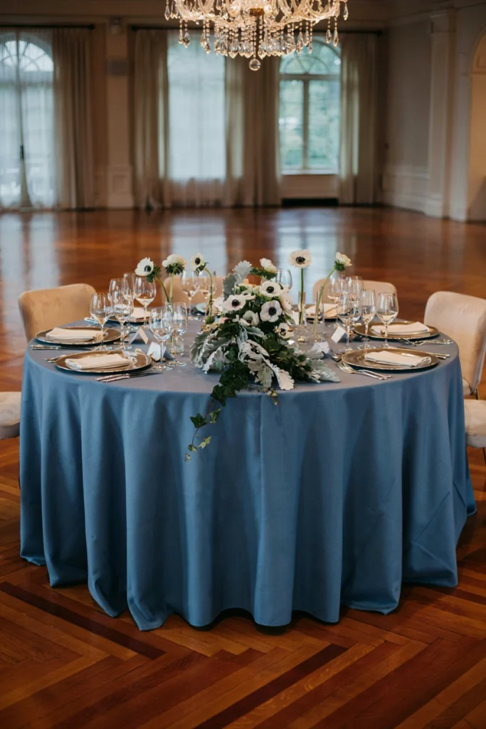 Sapphire blue winter wedding table with silver chargers and black-centered anemones