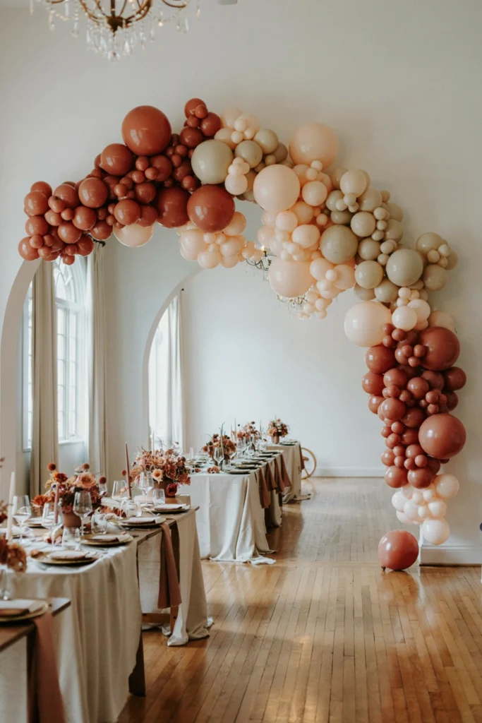 Dusty rose and terracotta balloon garland arch for a casual small wedding photobooth