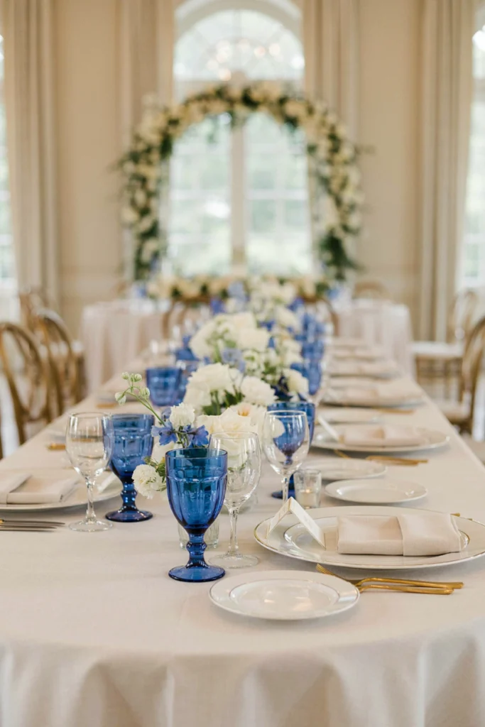 Cobalt blue water goblets against white china and gold flatware