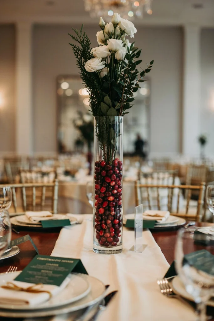 Glass cylinder filled with fresh cranberries and a candle