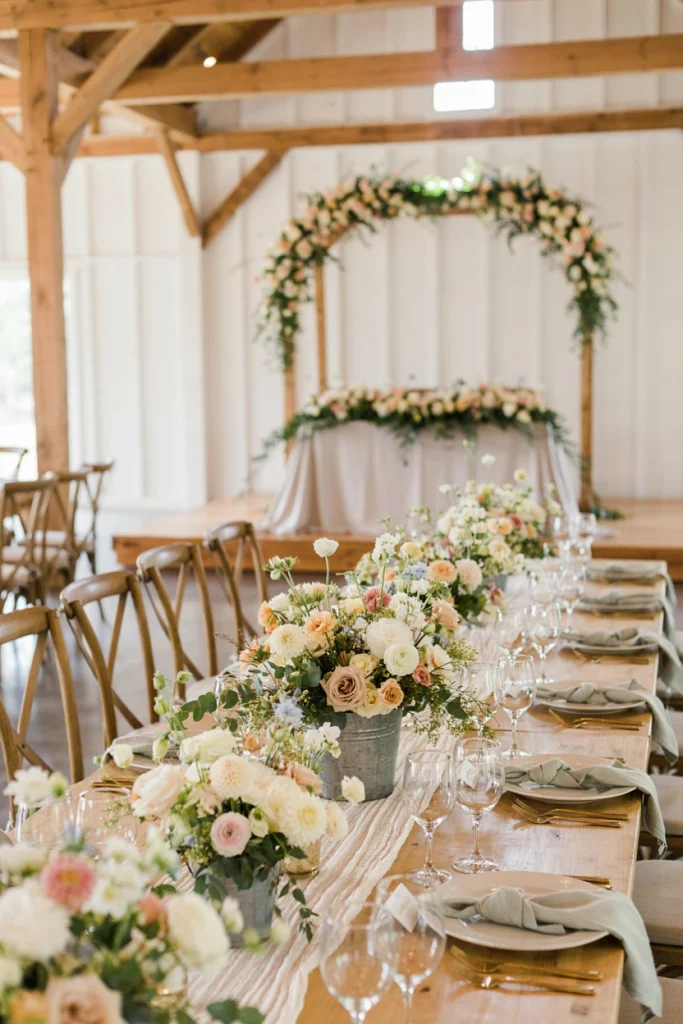 Galvanized metal bucket overflowing with wildflowers on a wooden picnic table