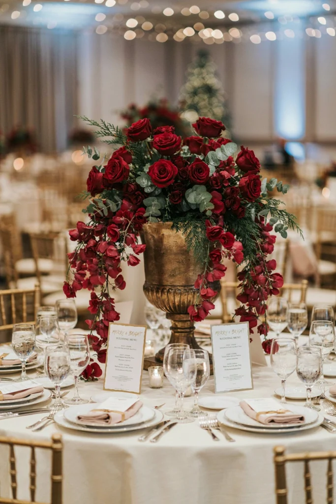 Deep red roses cascading over a tall urn with eucalyptus