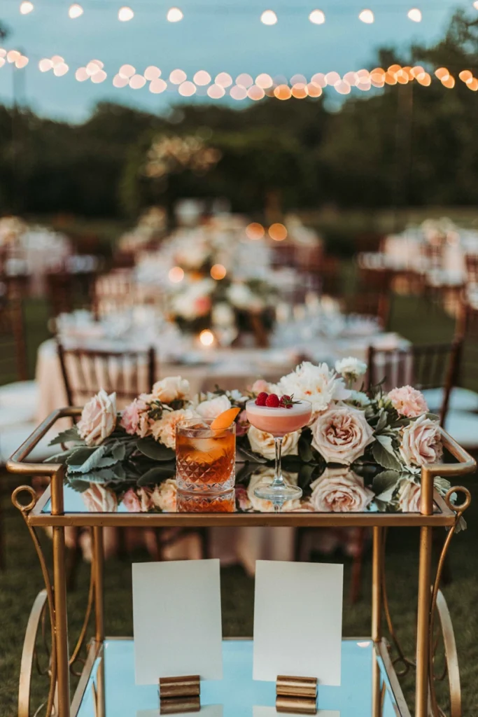Two custom wedding cocktails with handwritten name tags sitting on a bar cart