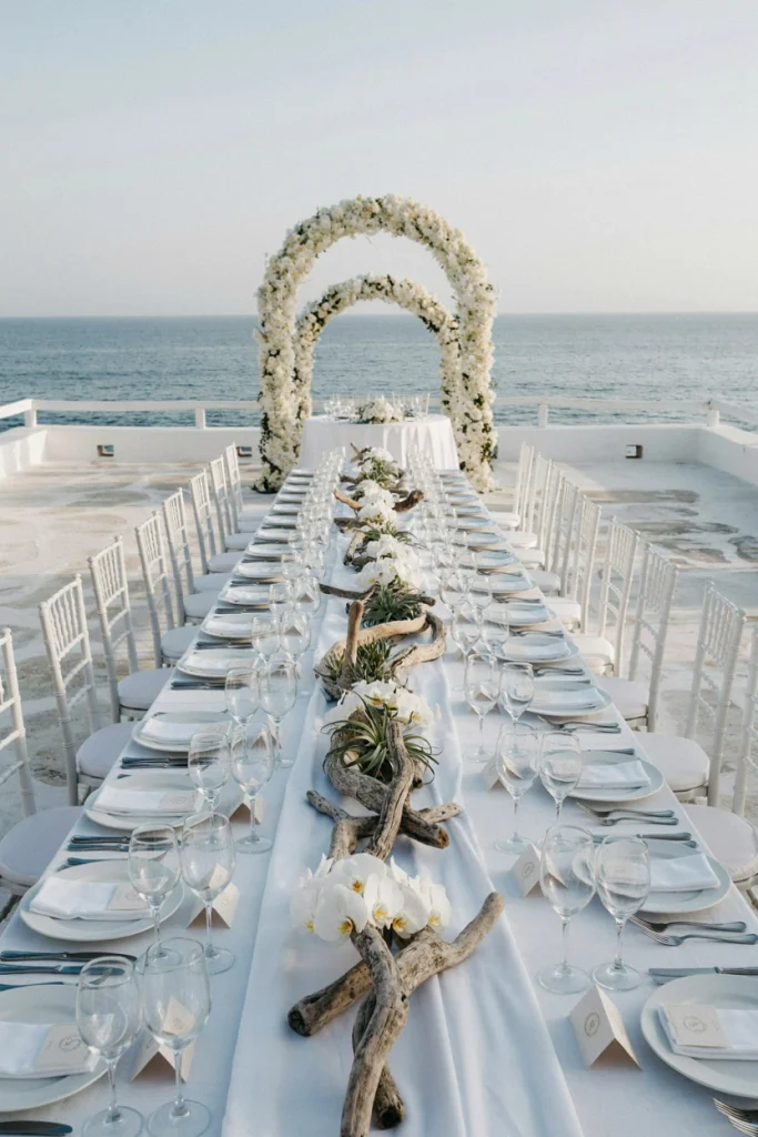 Weathered driftwood pieces with white orchids tucked among them