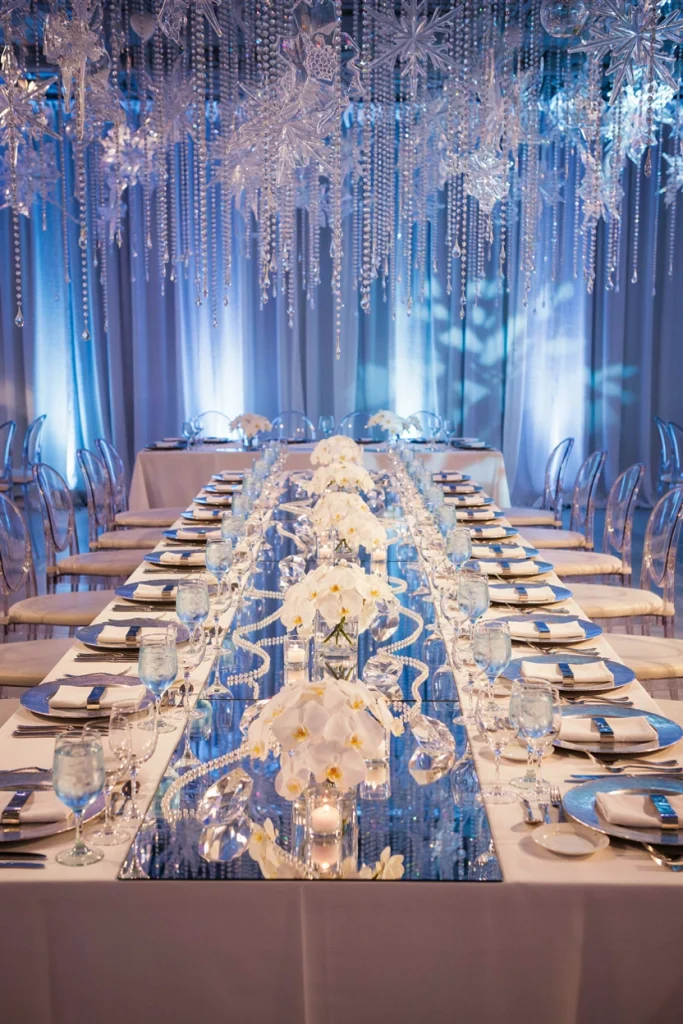 Wedding head table with mirrored runner reflecting rows of flickering candles