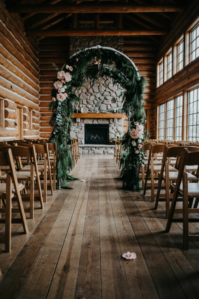 Evergreen ceremony arbor dusted with faux snow and blush peonies