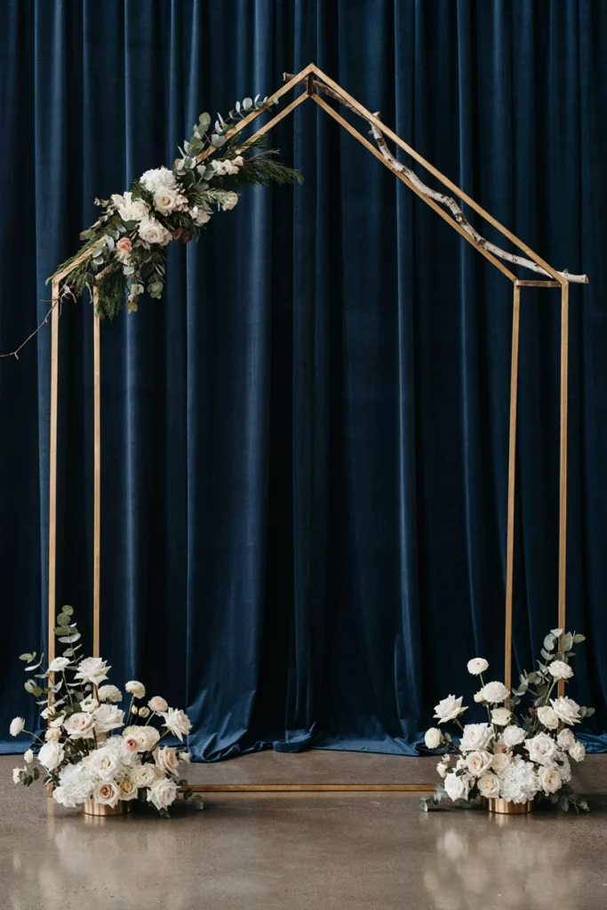 Modern geometric gold wedding arch with greenery garland and white floral base