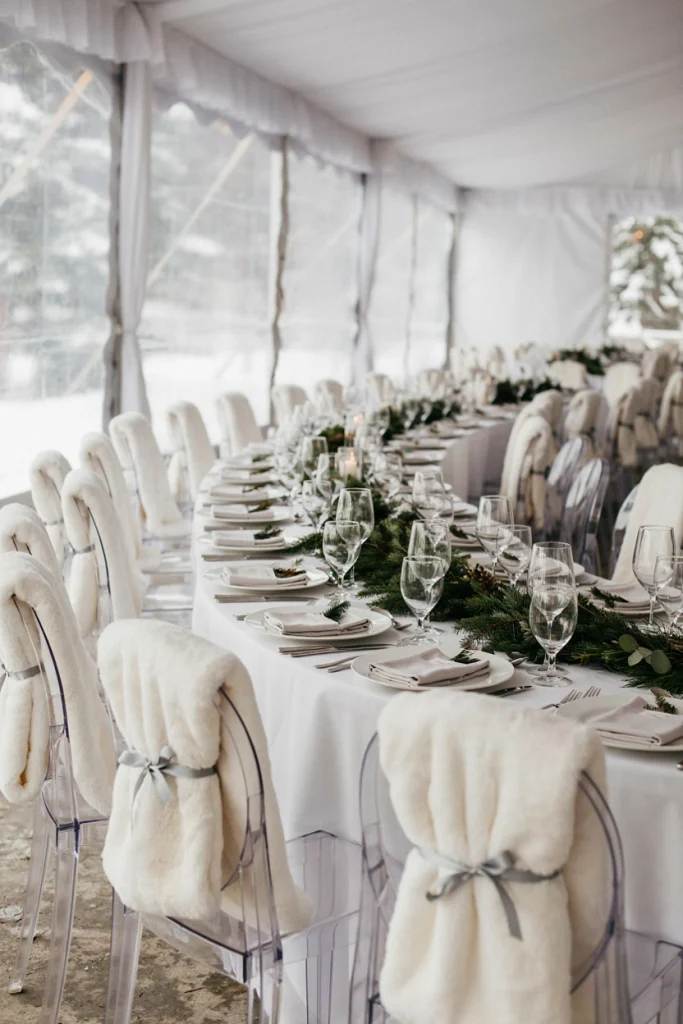 Clear ghost chair with a white faux fur throw draped over the back