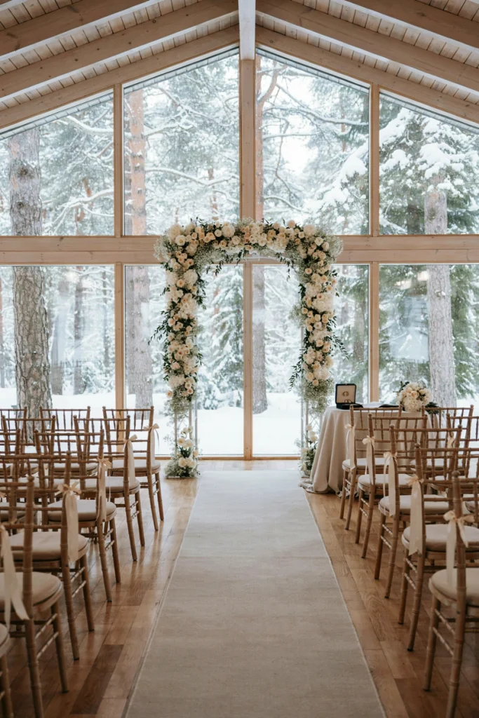 Glass-walled modern cabin with ceremony seating facing a snowy forest