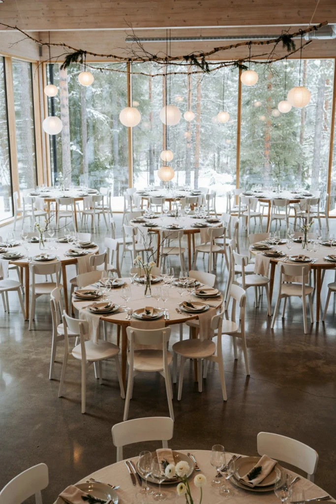 Clean white Scandinavian style reception with birch branches and simple candles