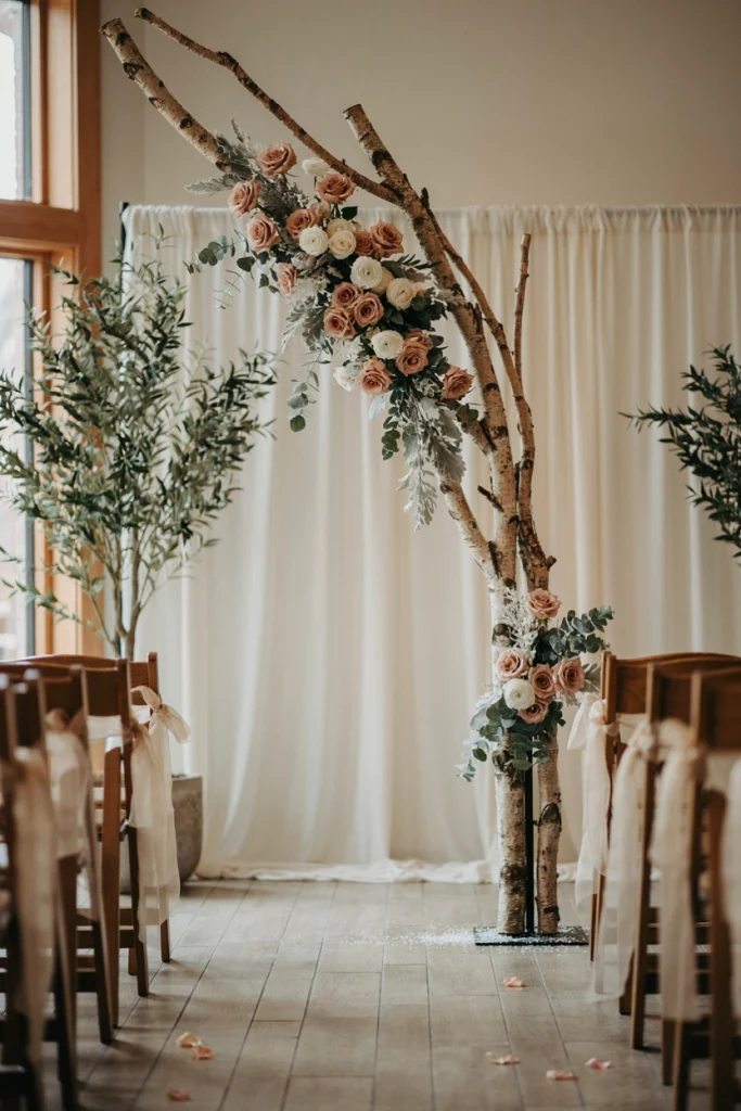 Blush floral ceremony arch with frosted eucalyptus and bare birch branches