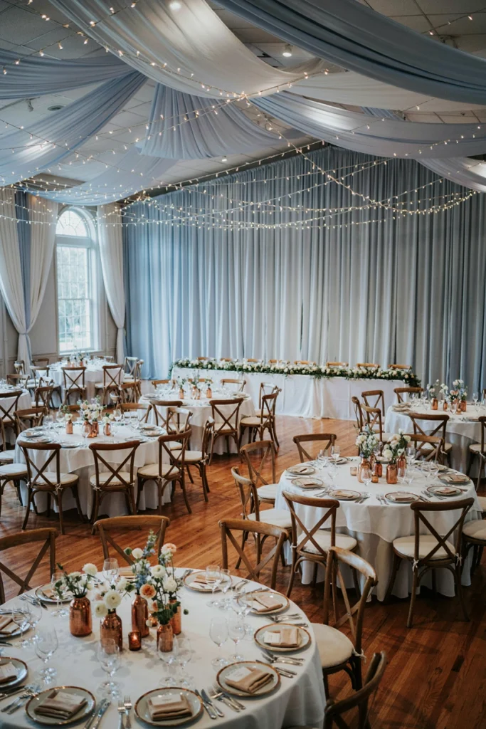 Copper vases with white florals against a pale blue backdrop