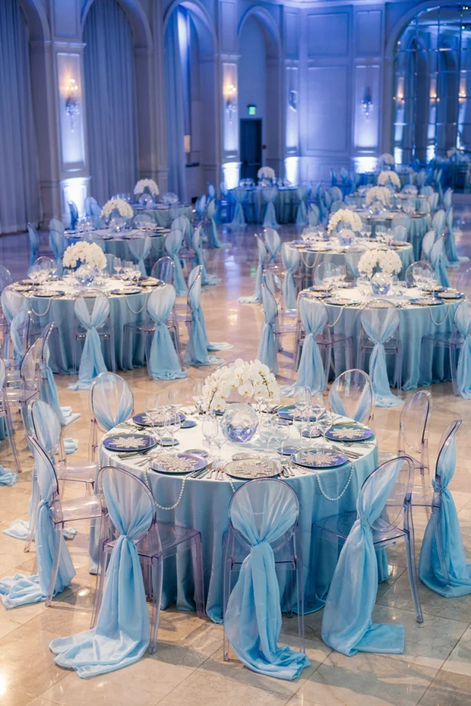 Wedding chairs draped in flowing ice blue chiffon fabric