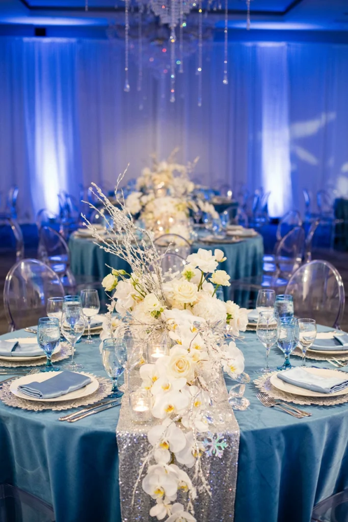 Low candlelit wedding tablescape with frosted glass charger plates