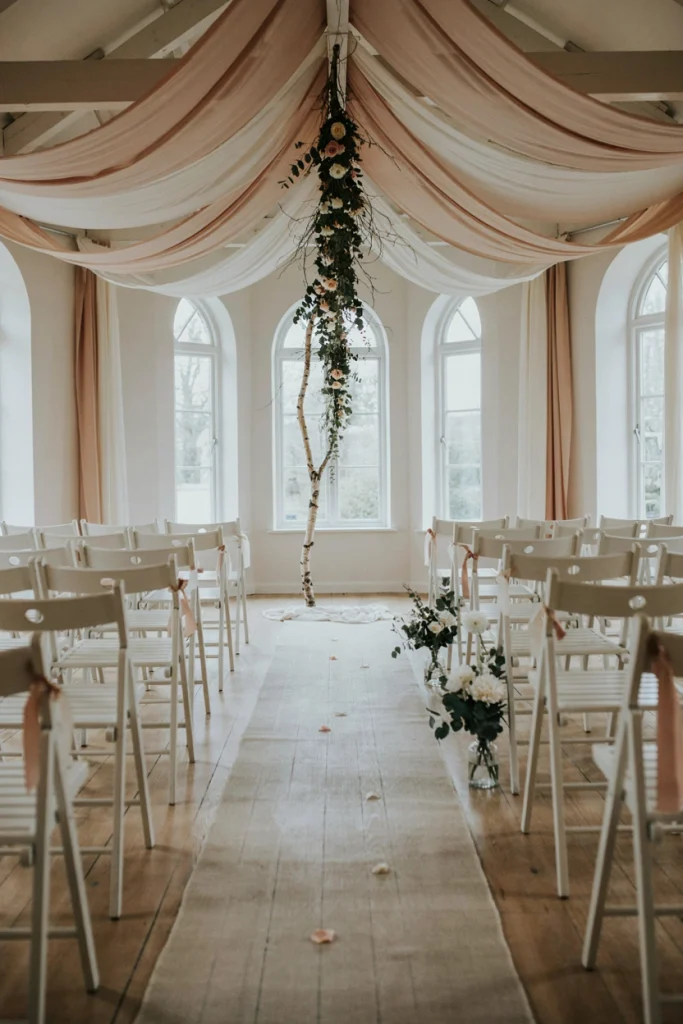 Blush and ivory chiffon canopy draped above an outdoor winter ceremony