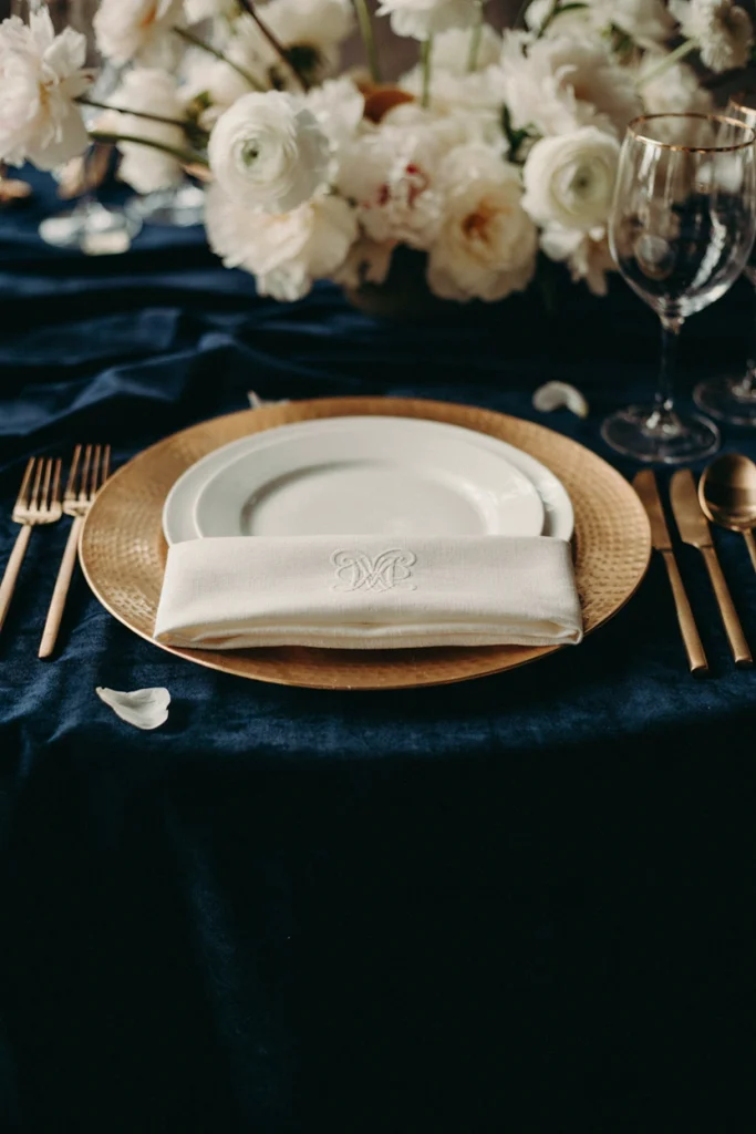 Navy table with metallic gold table runner and mismatched gold candle holders